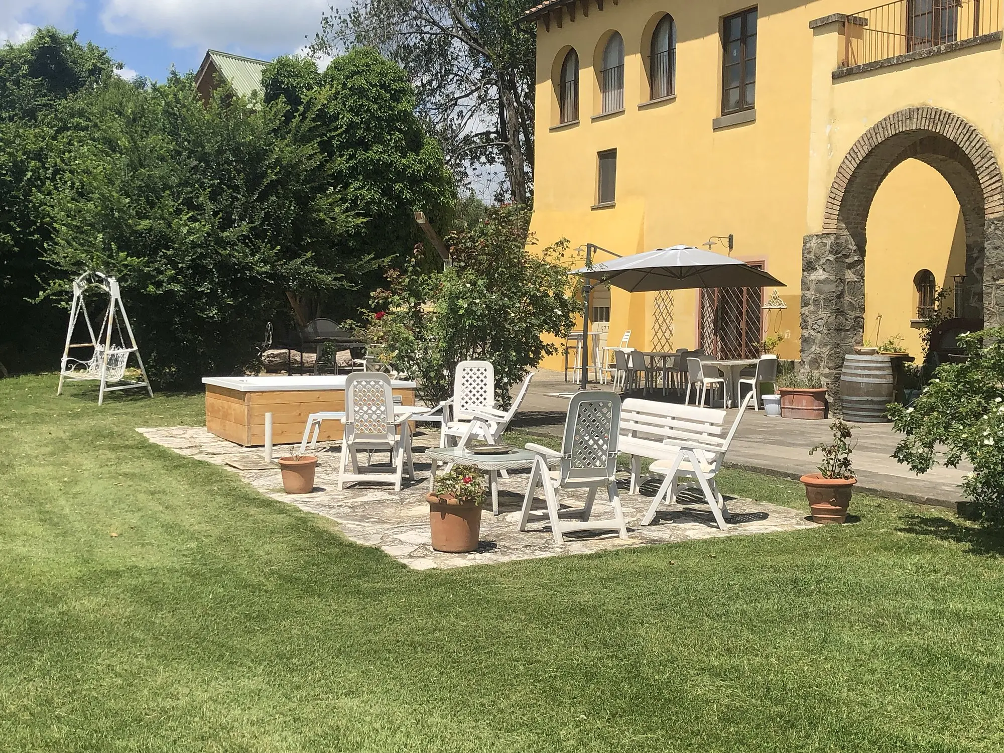 Il giardino del Casale Fedele con la Jacuzzi e il portico ad archi