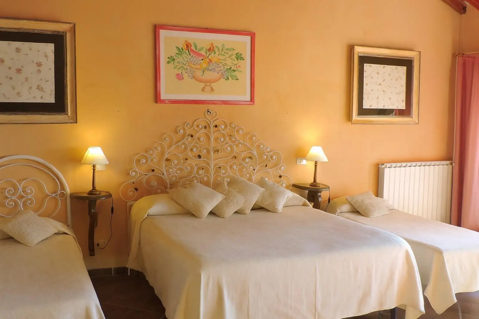 La camera della Suite Etrusca con il letto in ferro battuto e le lampade accese