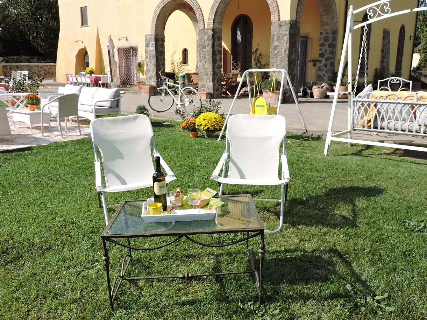 Due sedie e un tavolino sul prato, con l'altalena