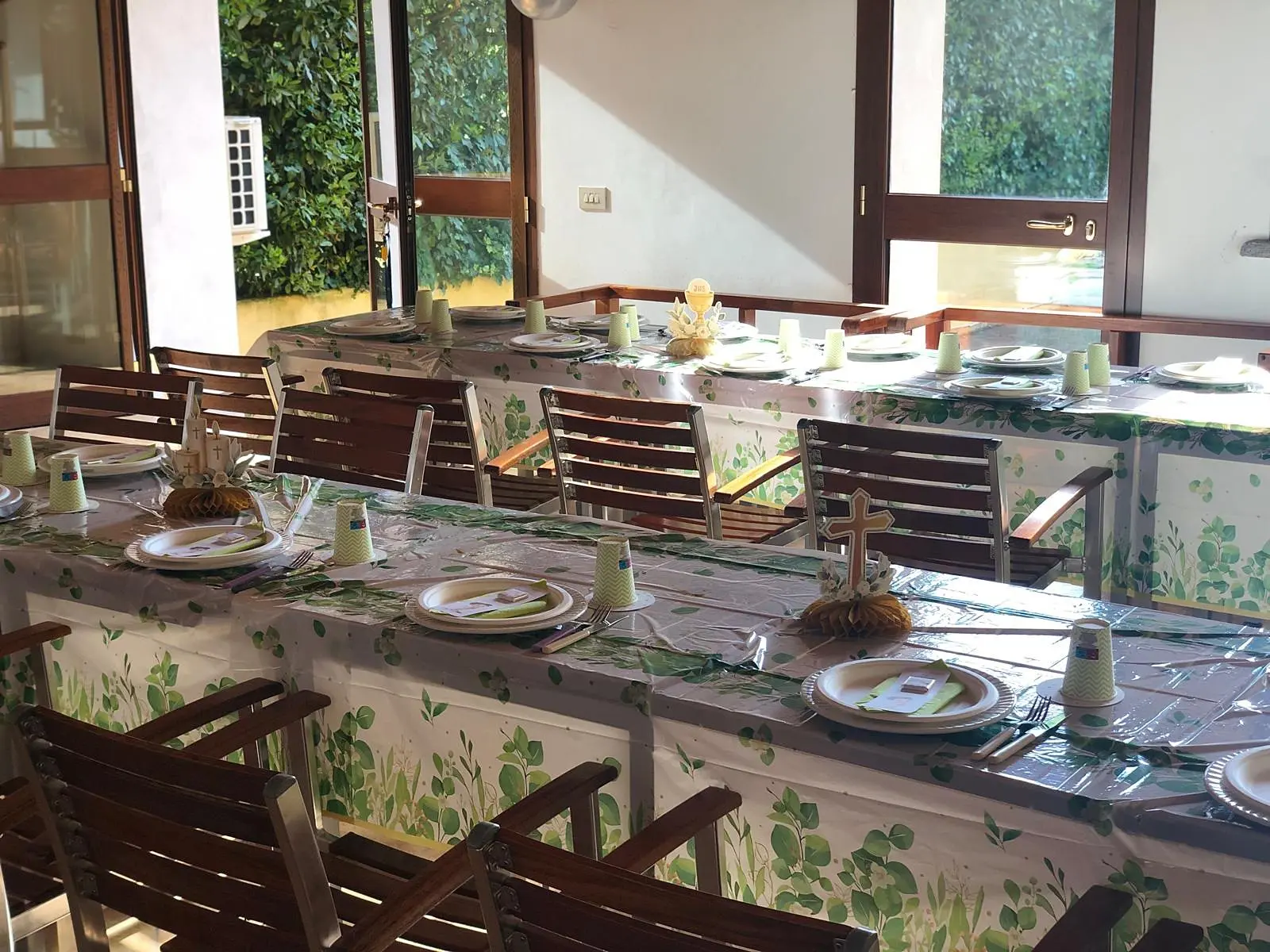 La sala eventi con la tavola apparecchiata e le finestre sul giardino